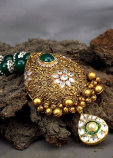 Gold kundan necklace on dark bark – jewellery photography