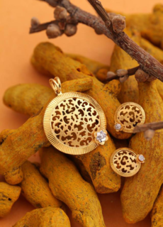 Gold filigree earrings on turmeric roots – creative jewellery photography