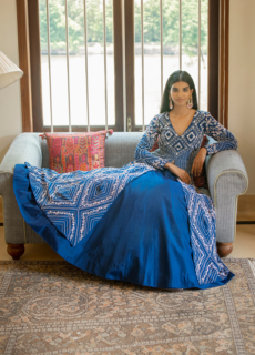 Woman in blue printed kurta set seated on a sofa – ethnic wear shoot