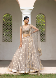 Model in ivory embellished lehenga under arches – bridal wear photoshoot