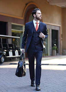 Male model in navy three-piece suit with bag – menswear fashion shoot