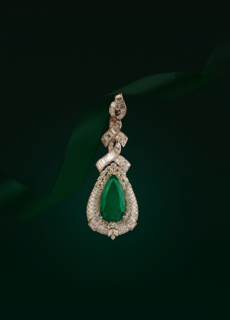 Emerald and diamond pendant on green backdrop – jewellery photography
